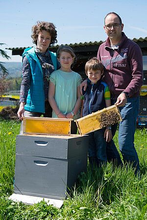 Mann, Frau und zwei Kinder hinter Bienestock