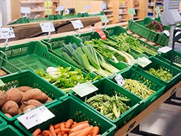 Verschiedenes Gemüse in grünen Körben wird in einem Laden zum Verkauf angeboten.
