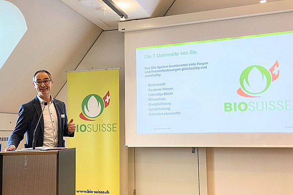 Ein Mann referiert vor einer Powerpoint-Präsentation