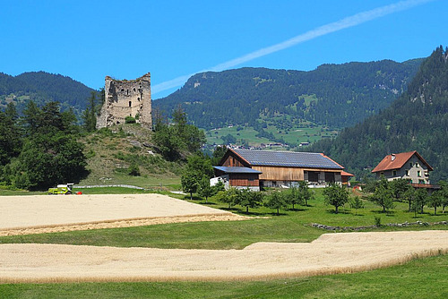 Betrieb mit Schlossruine, Getreidefeldern und Solaranlage auf dem Dach.