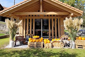 Ein Holzhaus mit Gemüseauslagen. 