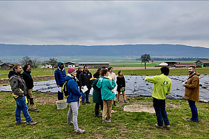 Eine Gruppe Menschen steht auf einem Feld.