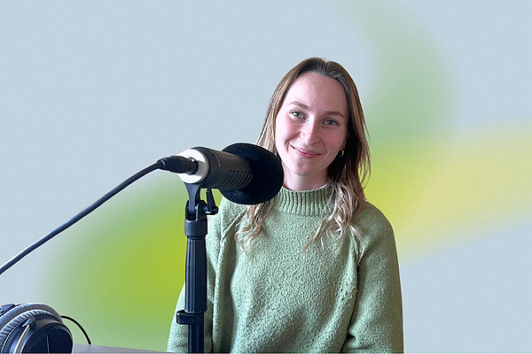 Eine Frau an einem Podcastmikrofon.
