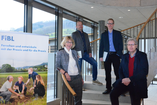 Die vier genannten Personen stehen auf einer Treppe