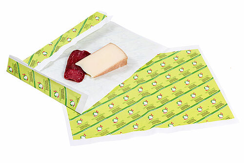 Käse- und Fleischstück auf Einwickelpapier mit der Umstellknospe Bio Suisse