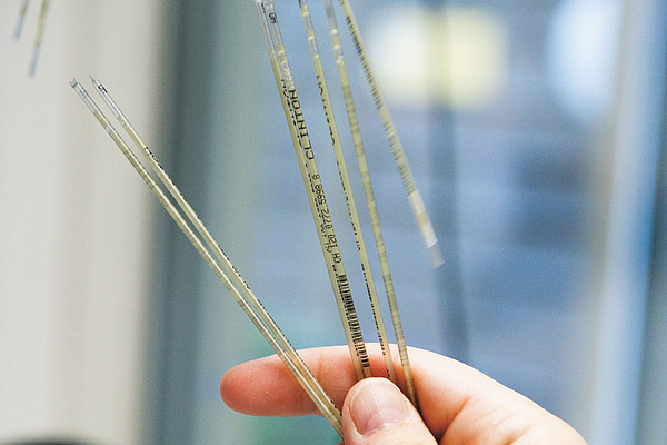 Hand hält einige Röhrchen mit Spermien. 