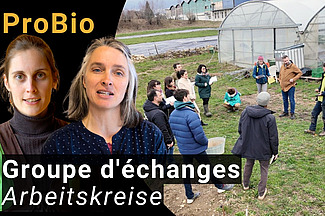 Zwei Frauen vor einem Bild mit einer Gruppe von Menschen vor einem Treibhaus.