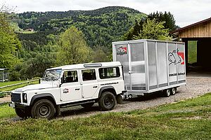 Weisser Land Rover mit Schlachteinheit-Anhänger