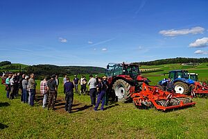 Landwirte neben Maschinen auf einem Feld