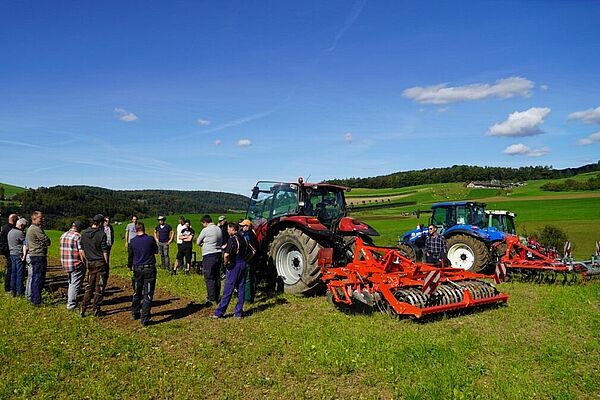 Landwirte neben Maschinen auf einem Feld