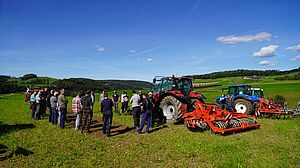 Landwirte neben Maschinen auf einem Feld