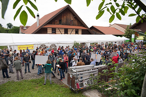 Grosse Menschenmenge vor einem Festzelt auf dem Hof.