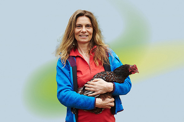 Eine Frau mit einem Huhn auf dem Arm.