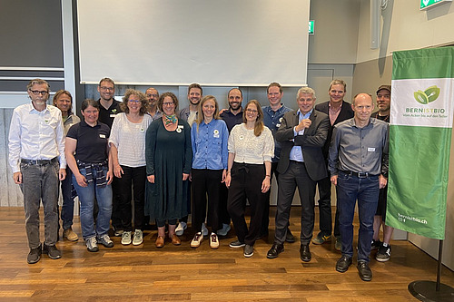 Ein Gruppenbild mit ca. 15 Personen in einem Saal. 
