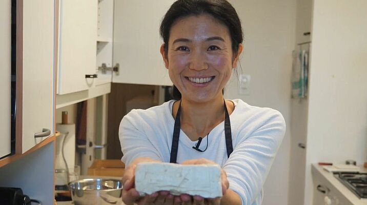 Tofu-Meisterin Mariko Kaufmann präsentiert einen frisch hergestellten Tofuwürfel.