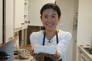 Tofu-Meisterin Mariko Kaufmann präsentiert einen frisch hergestellten Tofuwürfel.