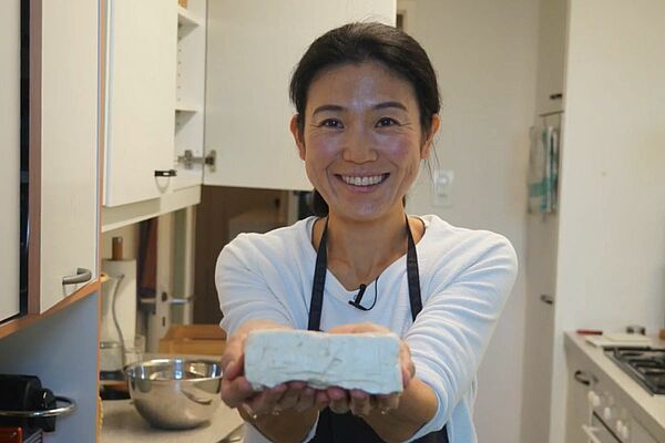 Tofu-Meisterin Mariko Kaufmann präsentiert einen frisch hergestellten Tofuwürfel.