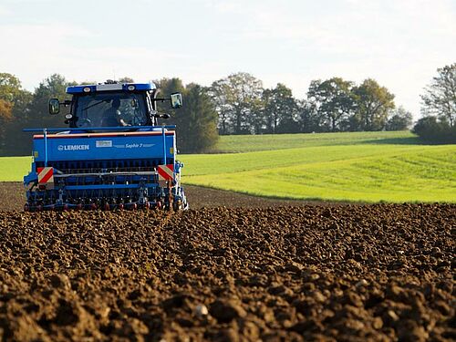 Traktor mit Sämaschine im Einsatz im Jura