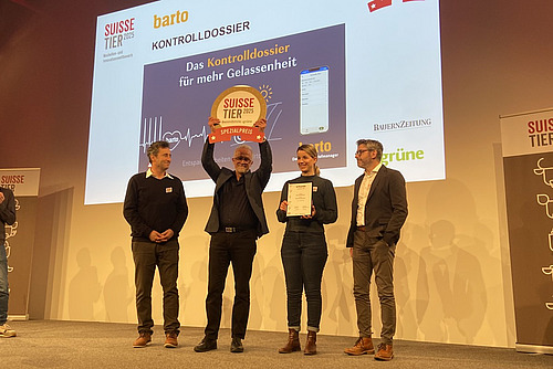 Vier Personen auf einer Bühne mit einer Auszeichnung.