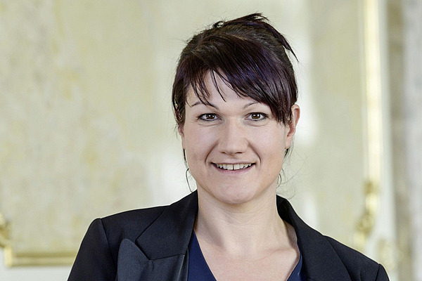 Porträtbild einer Frau mit glatten schwarzen Haaren. 