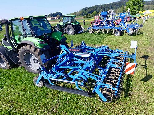 zwei Traktoren mit Grubbern im Feld