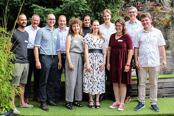 Ein Gruppenbild mit 11 sommerlich gekleideten Menschen. 