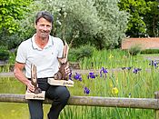 Roland Lenz mit zwei Trophäen vor einem Biotop