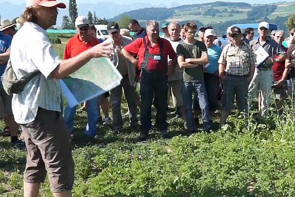 Referent mit Besuchergruppe im Versuchsfeld