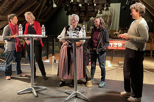 Fünf Frauen stehen auf einer Bühne für eine Podiumsdiskussion.