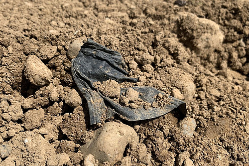Ein Stück Plastik auf einem Ackerfeld.