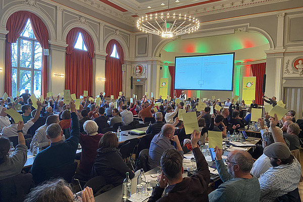 Eine Versammlung bei der Abstimmung mit gelben Stimmzetteln.