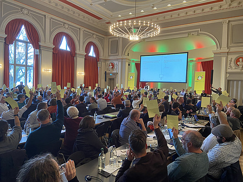 Eine Versammlung bei der Abstimmung mit gelben Stimmzetteln.