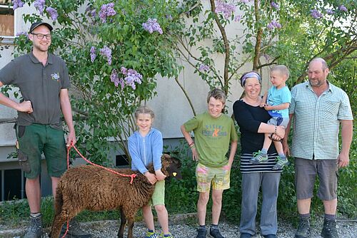 Gruppenbild mit Schaf vor einer Hauswand