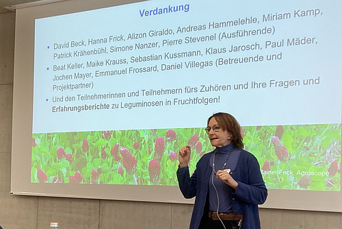 Eine Frau referiert vor einer Powerpoint-Präsentation. 