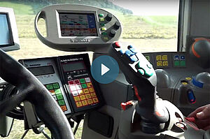 Im Cockpit eines modernen Traktors mit Bildschirmen und Joystick