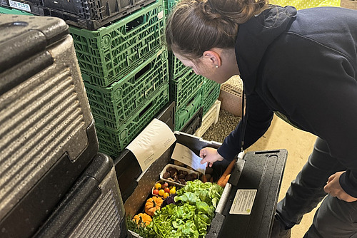 Eine Frau ordnet eine Sagex-Gemüsekiste. 