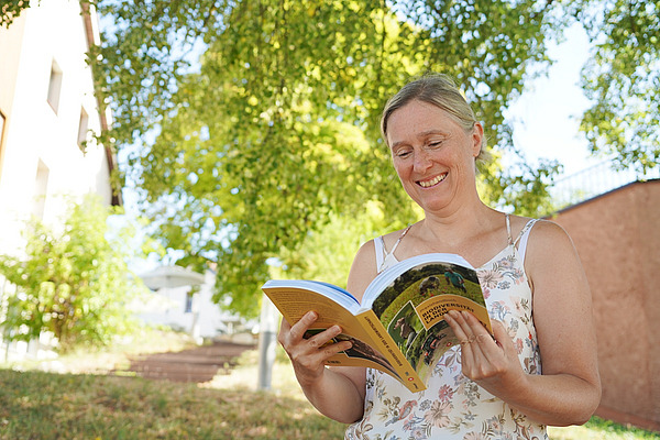 Eine Frau blätter durch ein Buch.