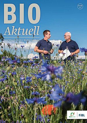 Titelseite Bioaktuell 9|2018: zwei Männer in blühendem Blühstreifen