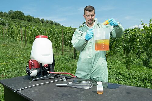 Ein Mann im Schutzanzug bereitet eine PSM-Behandlung vor.