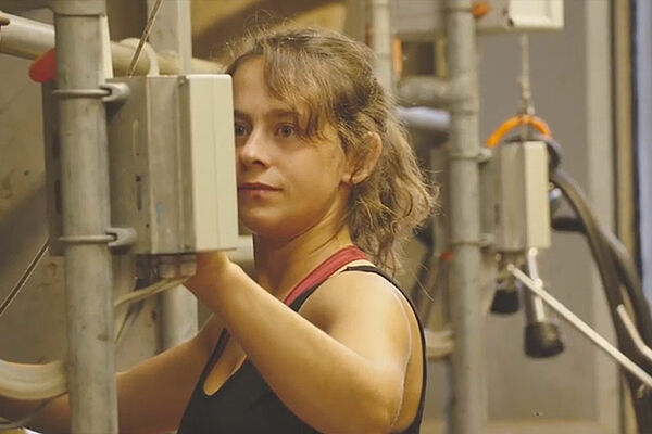 junge Frau beim Melken im Melkstand