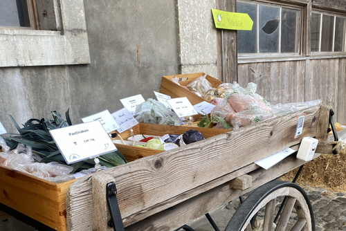 Ein Holzwagen mit Hofprodukten und Preisschildern