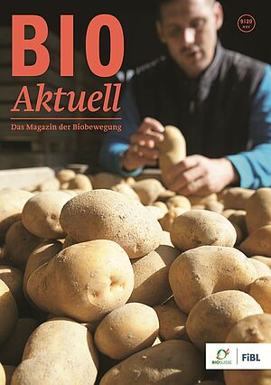 Titelseite Bioaktuell 9|2020: Mehrere Kartoffeln liegen aufeinander, im Hintergrund unscharf steht ein Mann.