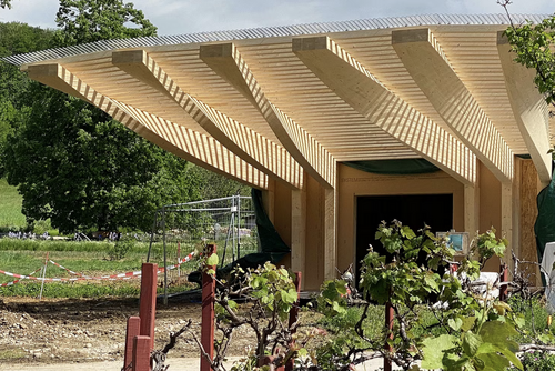 Holzbau mit ausladender Dachkonstruktion.