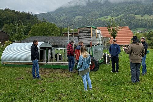 Saucarawan und 6 Personen, die auf der Wiese stehen