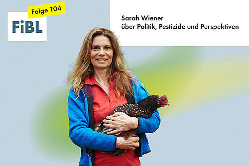 Eine Frau mit einem Huhn auf dem Arm.