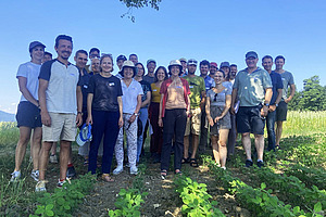 Eine Gruppe von etwa 25 Menschen posiert für ein Bild unter einem Baum.