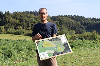 Ein Mann auf dem Feld mit einem Plan in der Hand.