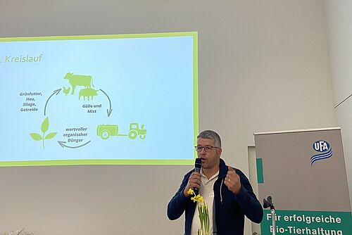 Ein Mann vor einer Powerpoint-Präsentation.