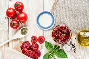 frische Tomaten und in Glas eingeglegte Tomaten, umgekehrter Schraubdeckel mit blauer Dichtung