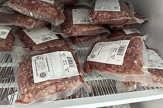 Vakuumiertes Fleisch im Kühlregal mit Haltbarkeitsdaten.